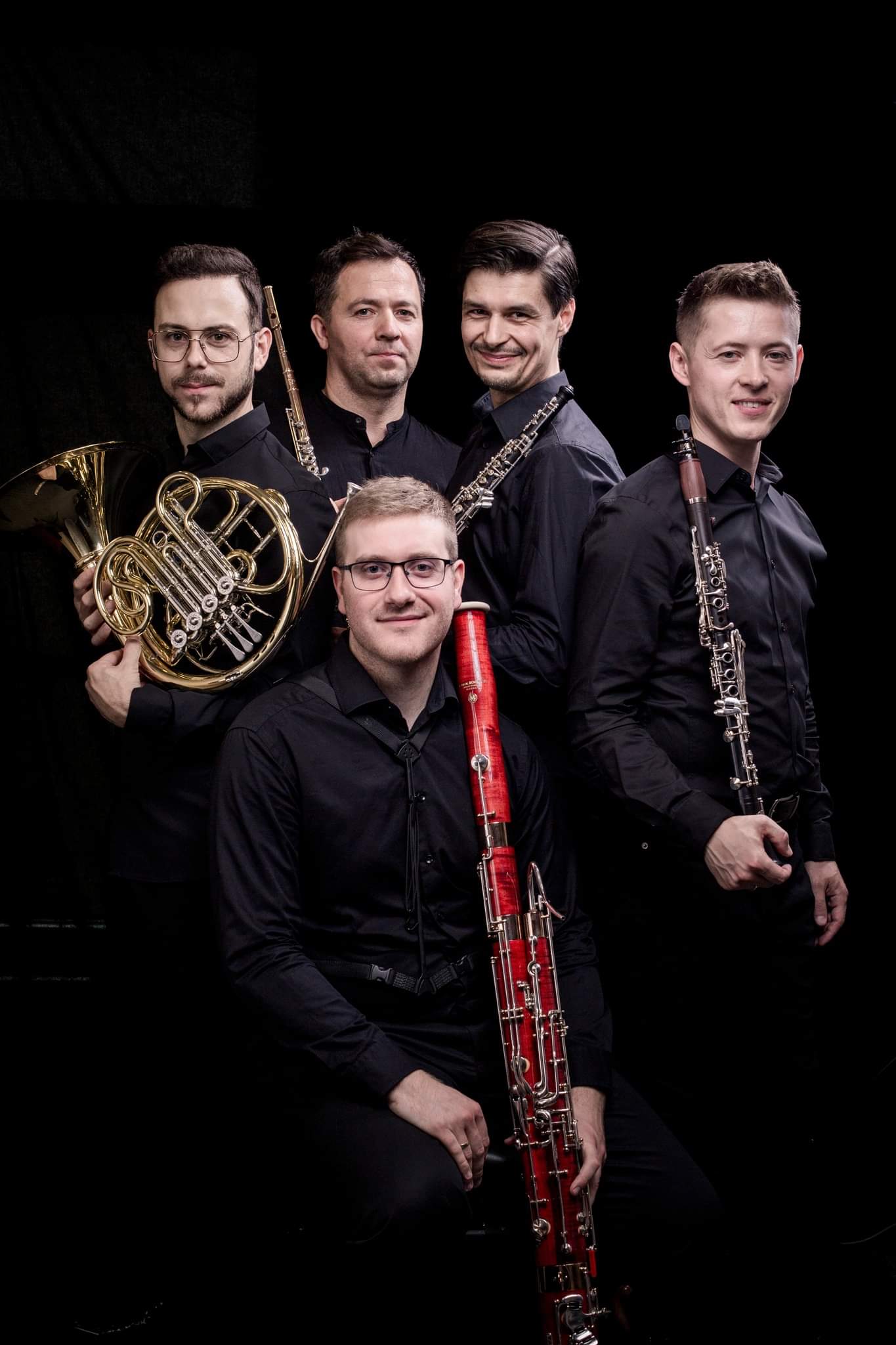 pięciu mężczyzn trzymających instrumenty dęte