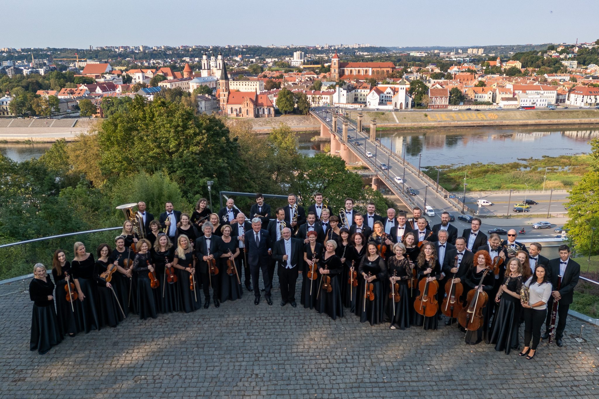 grupa stojących osób trzymających instrumenty muzyczne