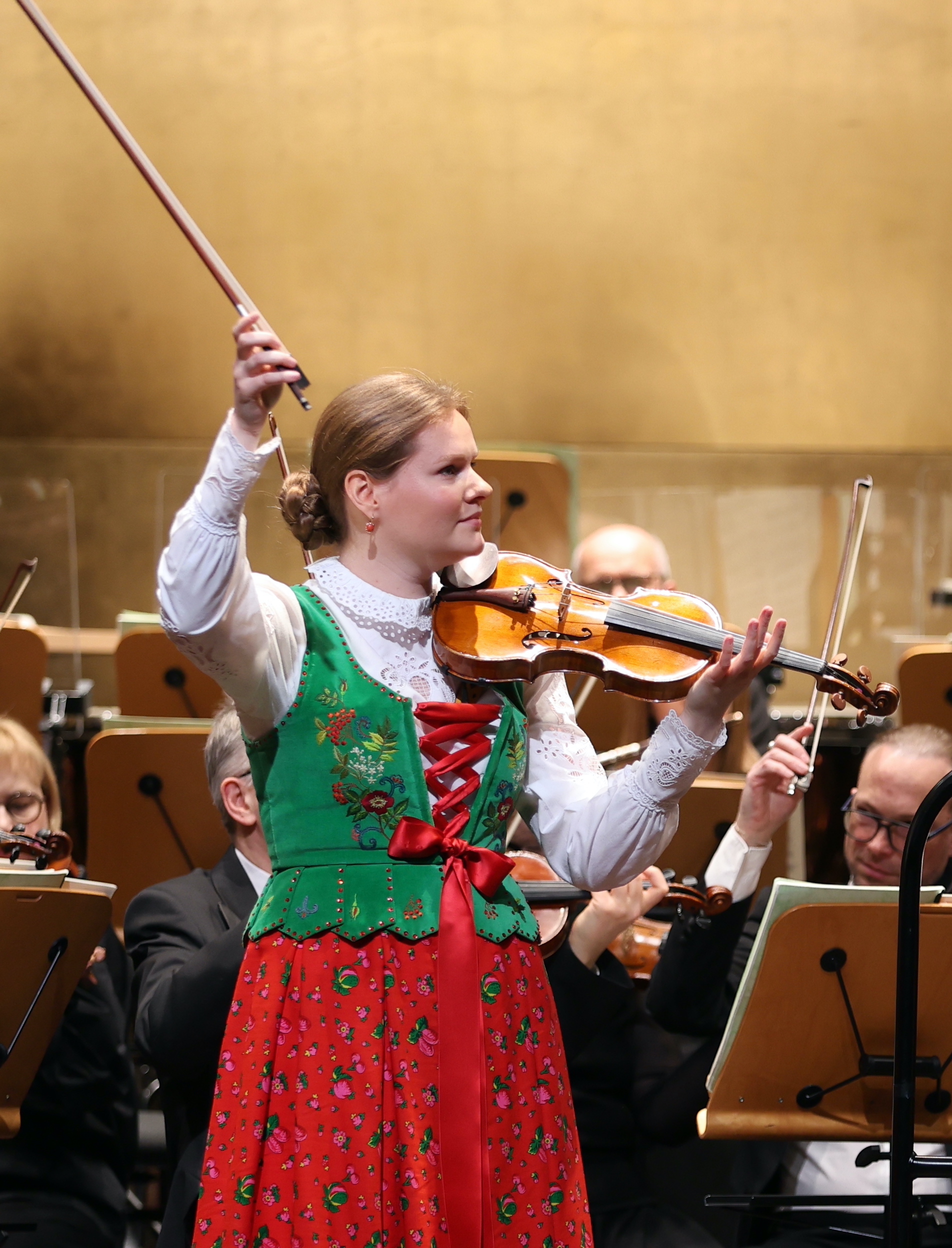kobieta w stroju góralskim gra na skrzypcach