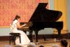 kobieta w białej sukni grająca na fortepianie