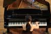 zbliżenie na kobietę w ciemnej sukni, grającej na fortepianie